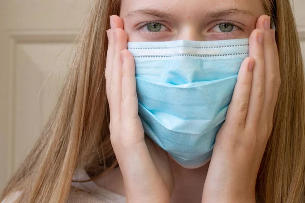 A girl wearing disposable face mask to prevent spreading of the viruses. Coronavirus and COVID-19 Concept
