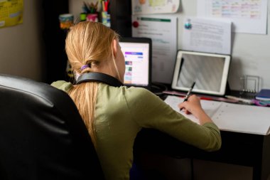 Evde kal, dizüstü bilgisayarı, bilgisayarı ve tableti olan genç bir kız evde internetten öğreniyor. Kişisel izolasyon koronavirüs kavramı