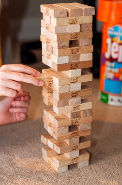 Evde kalıp koronavirüs konseptini bozma. Eller tahta blok jenga oyunu oynuyor