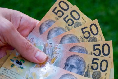 Avusturalya dolarlarını tutan eller. Ödeme yapmak için 50 banknot.