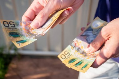 Ödeme yapmak için Avustralya doları tutan eller - Coronavirus finans mücadelesi konsepti