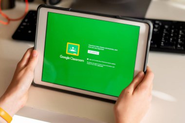 Sydney, Avustralya - 2020-04-06 Hands ekranda Google Sınıfı uygulaması olan bir tablet tutuyor. Coronavirus çevrimiçi eğitim kavramını kilitledi