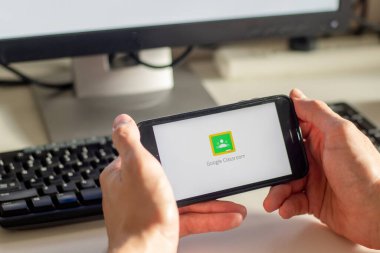 Sydney, Avustralya - 2020-04-06 Hands Google Sınıfı uygulamalı akıllı bir telefon tutuyor. Coronavirus çevrimiçi eğitim kavramını kilitledi