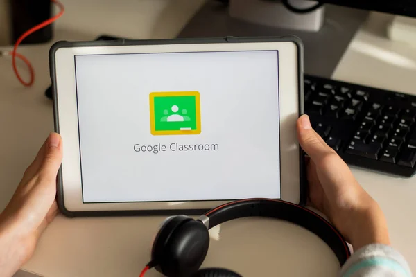 Sydney, Avustralya - 2020-04-06 Hands ekranda Google Sınıfı uygulaması olan bir tablet tutuyor. Coronavirus çevrimiçi eğitim kavramını kilitledi
