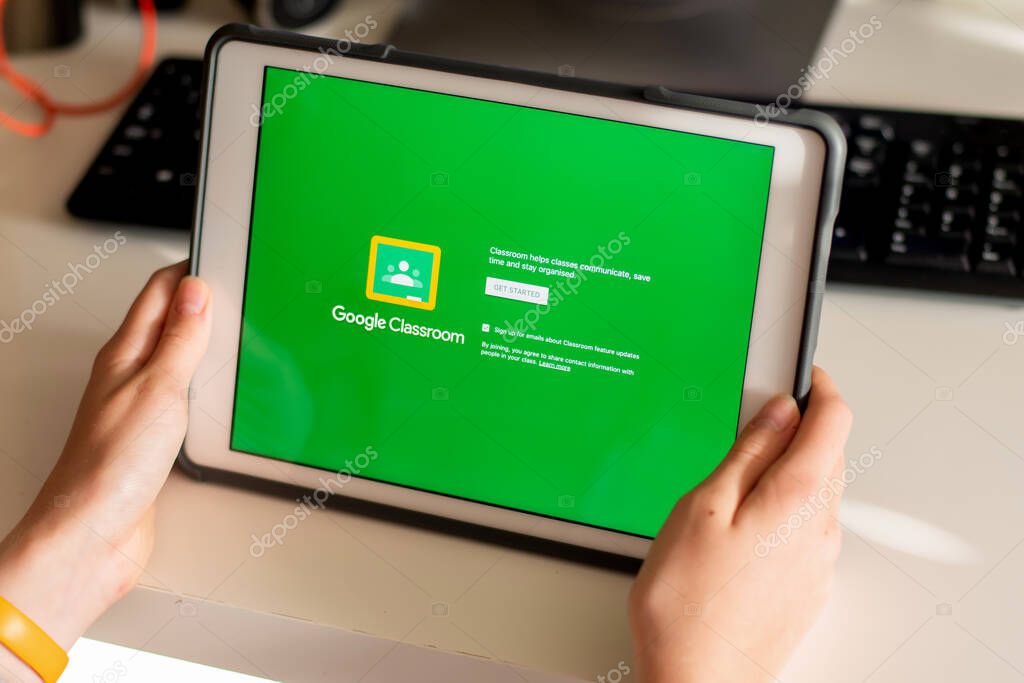 Sydney, Australia - 2020-04-06 Hands holding a tablet with Google Classroom application on screen. Coronavirus lockdown online education concept