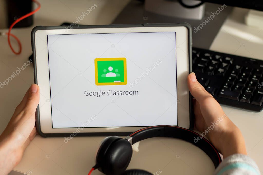 Sydney, Australia - 2020-04-06 Hands holding a tablet with Google Classroom application on screen. Coronavirus lockdown online education concept
