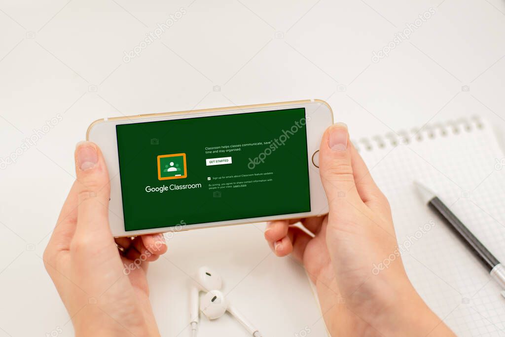 Sydney, Australia - 2020-04-06 Hands holding a smart phone with Google Classroom application. Coronavirus lockdown online education concept