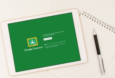 Sydney, Avustralya - 2020-04-06 Hands ekranda Google Sınıfı uygulaması olan bir tablet tutuyor. Coronavirus çevrimiçi eğitim kavramını kilitledi