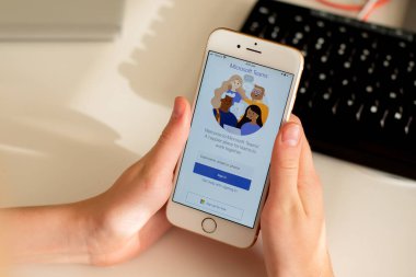 Sydney, Avustralya - 2020-04-15 Hands Microsoft Team ile birlikte akıllı telefonu tutuyor - takım çalışması merkezi ve grup sohbet uygulaması. Coronavirus çevrimiçi eğitim ve ev kavramından çalışma