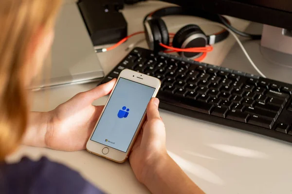 Sydney, Avustralya - 2020-04-15 Hands Microsoft Team ile birlikte akıllı telefonu tutuyor - takım çalışması merkezi ve grup sohbet uygulaması. Coronavirus çevrimiçi eğitim ve ev kavramından çalışma