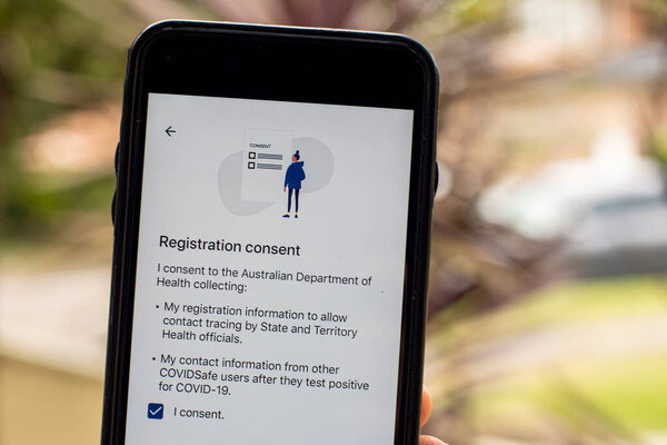 Sydney, Australia 2020-04-26 Hand holding a phone with CovidSafe app. Registration consent screen. Australian Government introduced new COVID-19 trace tracking app