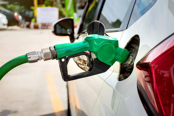 White car refueling at gas station with green fuel nozzle. — Stock Photo, Image