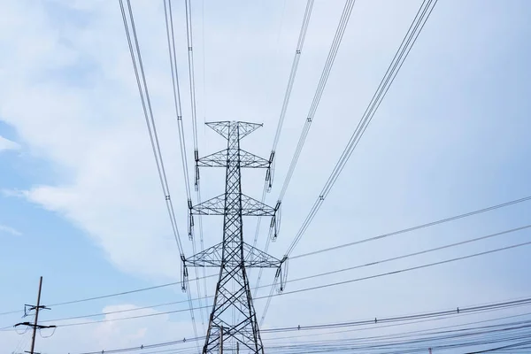 Mavi gökyüzü ve bulutlara karşı yüksek voltajlı elektrik kulesi. — Stok fotoğraf