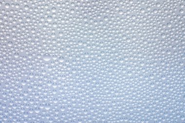 Beyaz yüzey arka planında su damlaları.