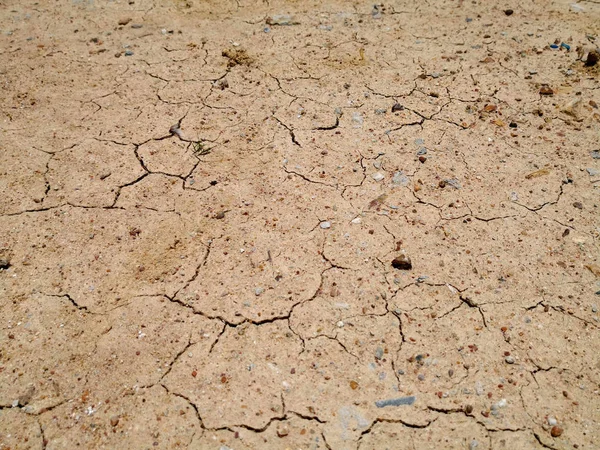 Sprucken av torr jord under torra årstider. Torr sprucken jordstruktur. — Stockfoto