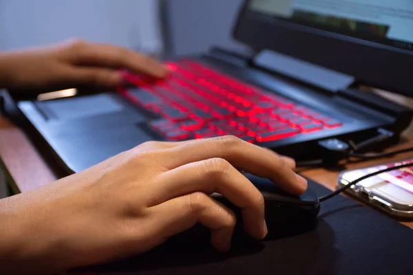 Close up woman hands using laptop computer are working or play game with red light LED backlit keyboard. — 스톡 사진