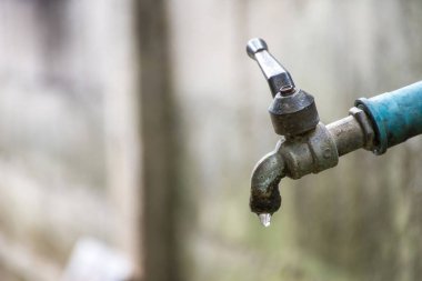 Su sızıntısı olan eski musluk yere düşüyor.