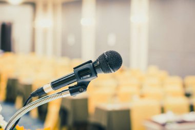 Seminer odasında sahnede mikrofon ya da konferans salonunda konuşma ya da soyut bulanık arkaplan ile eğitim semineri sınıfında. Mikrofona seçici odaklanma