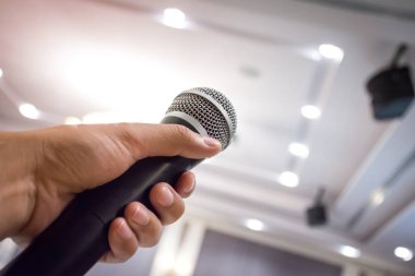 Konferans salonunda ya da konser salonunda mikrofonu tutan adamın elini kapatın..