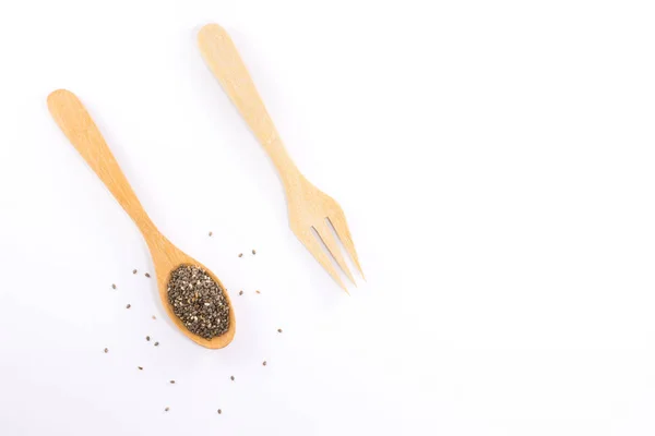 Wooden spoon and wooden fork with plant seeds isolated on white background and copy space. — Stock Photo, Image