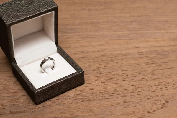 Anillo de boda de diamantes en la caja en la mesa de madera . — Foto de Stock