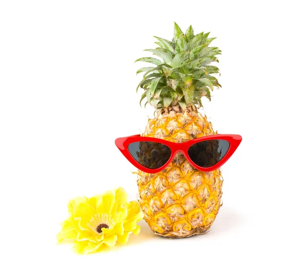 Свежий ананас в красных солнцезащитных очках и цветок на белом фоне. — стоковое фото