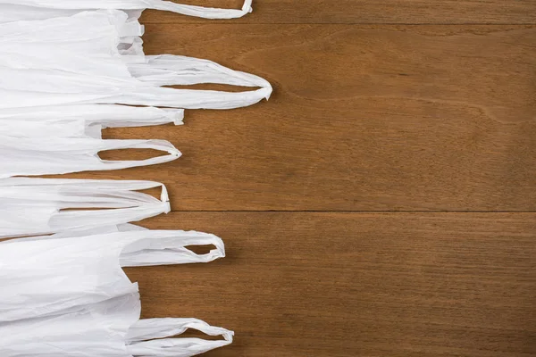 Valkoinen muovipussi puinen tausta. Vähennä kierrätyskonseptia . — kuvapankkivalokuva
