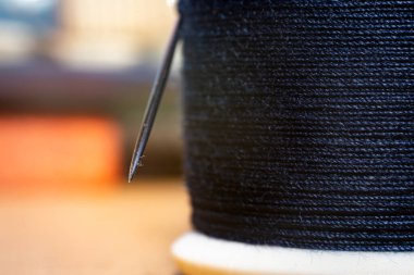 İğne ve mavi iplikten oluşan makroyu kapat.