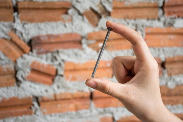 Vrouwelijke Hand Met Een Constructie Nagel Met Baksteen Muur Achtergrond — Stockfoto