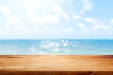Bulanık mavi deniz ve gökyüzü arka planındaki ahşap masa. Görüntü veya montaj ürün tasarımı için boşluk kopyala.