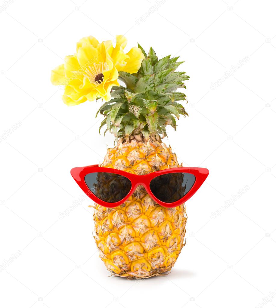 Fresh pineapple wearing red sunglasses and flower isolated on white background.