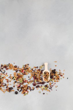 aromatik kuru çay, meyveli ve mavi arka planda kaşık yapraklı.