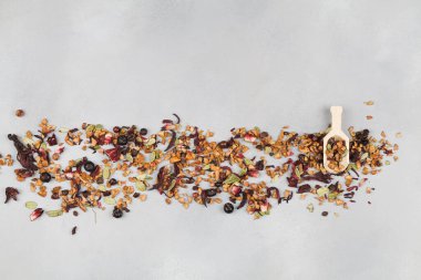 aromatik kuru çay, meyveli ve mavi arka planda kaşık yapraklı.