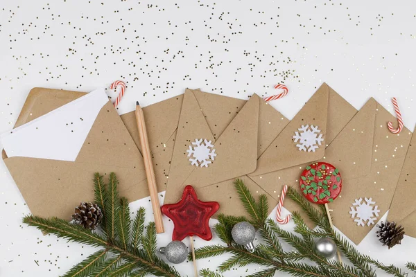 Christmas tree branches, red lollipops and decorations with envelopes on white background. — Stock Photo, Image