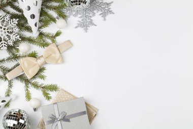 Beyaz papyonlu ve süslemeli Noel arkaplanı: toplar, ağaç dalları, şapkalar. Noel erkek modası..