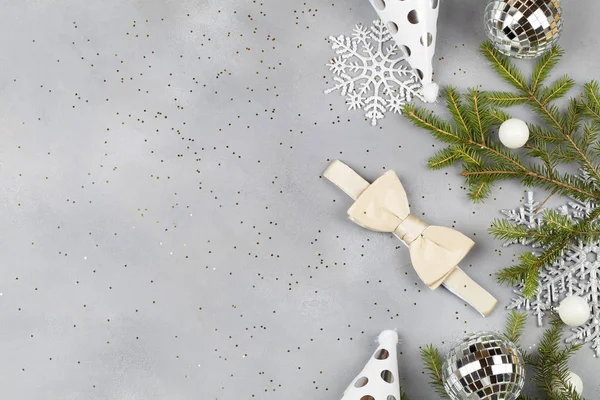 Χριστουγεννιάτικο φόντο με λευκό παπιγιόν και διακοσμήσεις: μπάλες, κλαδιά δέντρων, καπάκια. Χριστουγεννιάτικη ανδρική μόδα. — Φωτογραφία Αρχείου