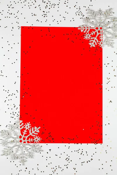 Vánoční kompozice. Vánoční rám ze sněhových vloček na červeném a bílém pozadí. Zimní koncept. — Stock fotografie