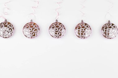 Beyaz arka planda pembe kurdeleler asılı Noel pembe topları.