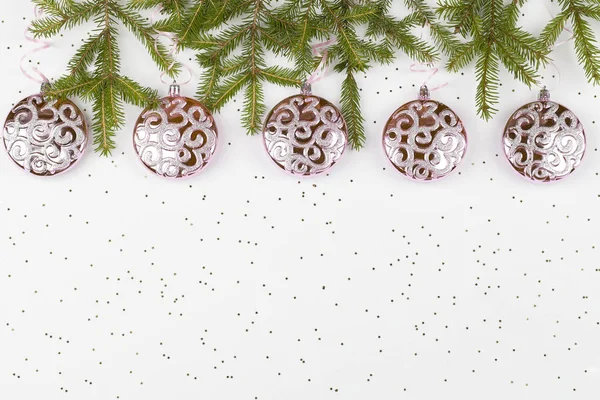 Karácsonyi rózsaszín golyók lógó rózsaszín szalag és faágak fehér alapon kis csillagok — Stock Fotó