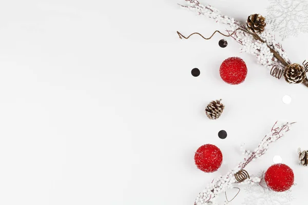 Composición navideña con bolas rojas de Navidad, conos, copos de nieve y ramas de árboles sobre fondo blanco — Foto de Stock