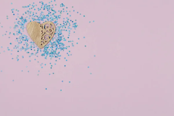 Corazón de madera con motivos sobre fondo rosa con estrellas azules — Foto de Stock