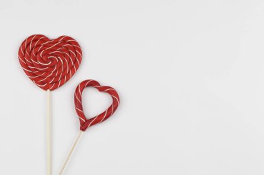 Kırmızı kalpler lolipop şekeri gibidir. Sevgililer Günü minimalist geçmişi. kırmızı kalp, aşk sembolü, metin konsepti için boşluk.