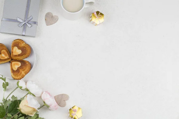 白い背景にハート、装飾品、ギフト、お茶や花の形をしたカップケーキ。バレンタインデーの背景. — ストック写真