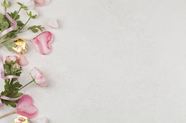 Kalpler, çiçekler, dekorasyon, hediyeler ve beyaz arka planda kurdele şeklinde pembe lolipoplar..