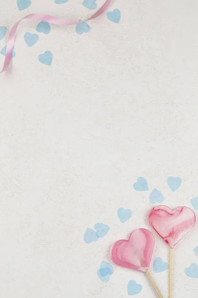 하얀 배경에 파란 하트를 가진 롤리팝 캔디 두 개의 핑크 하트. — 스톡 사진