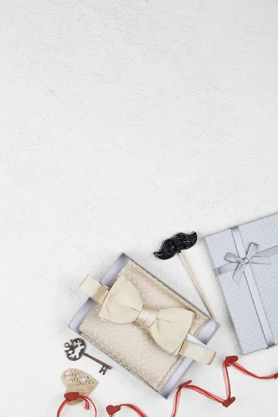 Μαύρο γλειφιτζούρι μουστάκι, διακόσμηση, παπιγιόν και δώρο σε λευκό φόντο. Ημέρα του Αγίου Βαλεντίνου φόντο. — Φωτογραφία Αρχείου