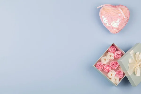 Gift or present box with small roses and pink heart on blue background. top view close up . — 스톡 사진