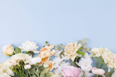 Mavi arka planda canlı renklere sahip çeşitli farklı çiçekler.