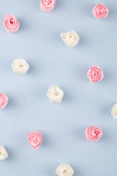 Kuvio vaaleanpunainen ja valkoinen kirkkaita ruusuja sinisellä taustalla . — kuvapankkivalokuva