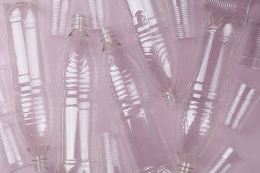 boş plastik şişeler ve pembe arka planda gözlük.